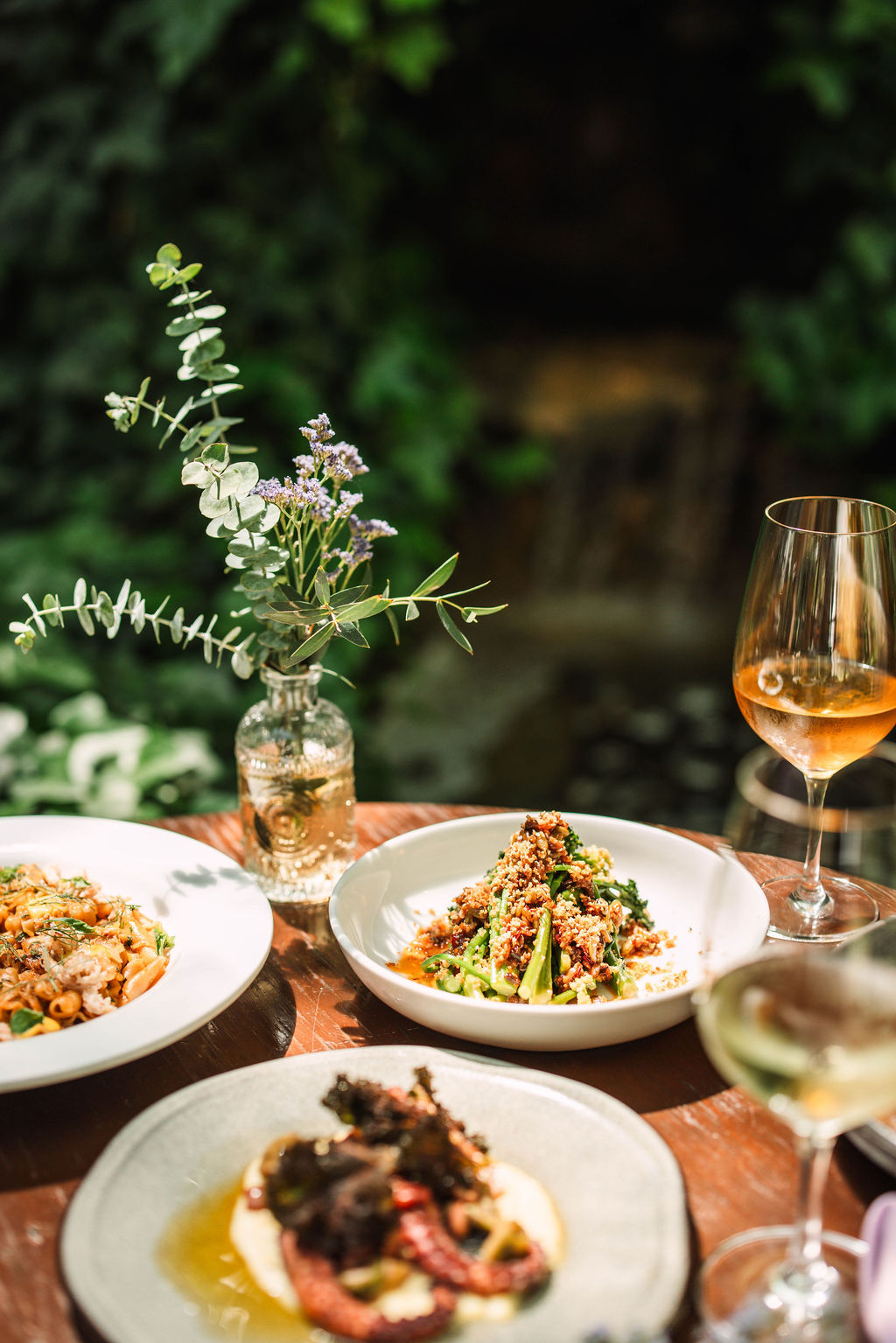 Seasonal plates and wine at a garden celebration