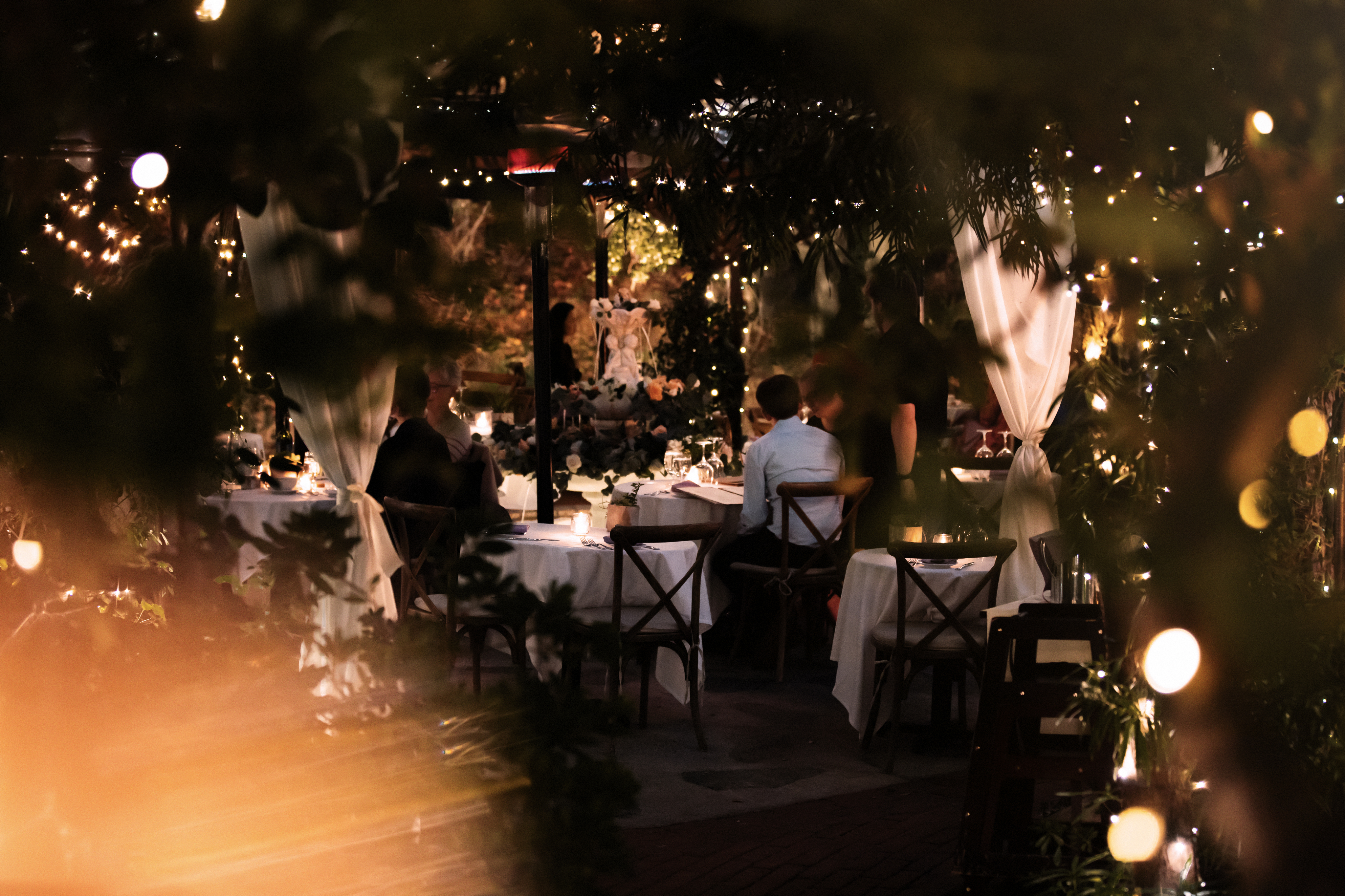 Evening reception glowing through the garden greenery