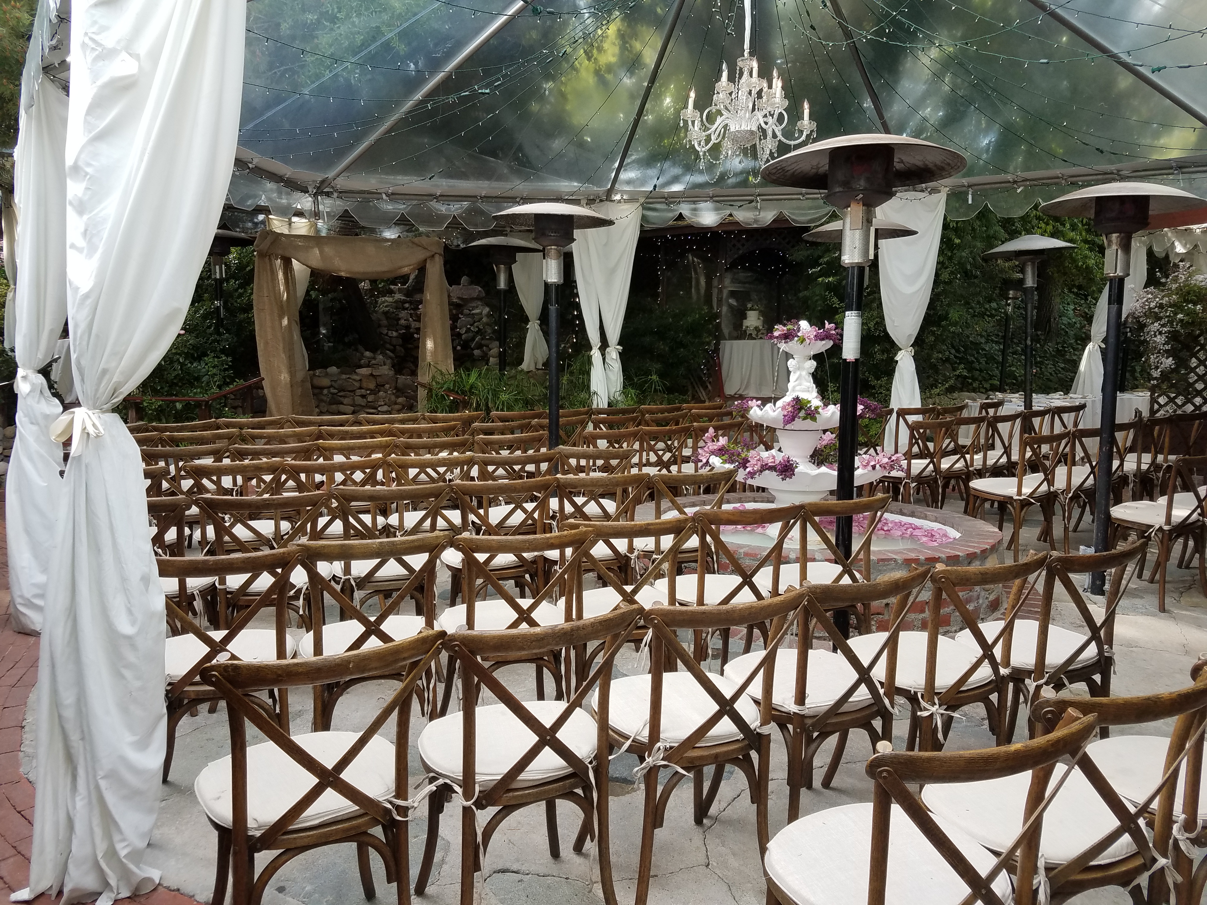 Ceremony beneath the clear-top tent and chandelier